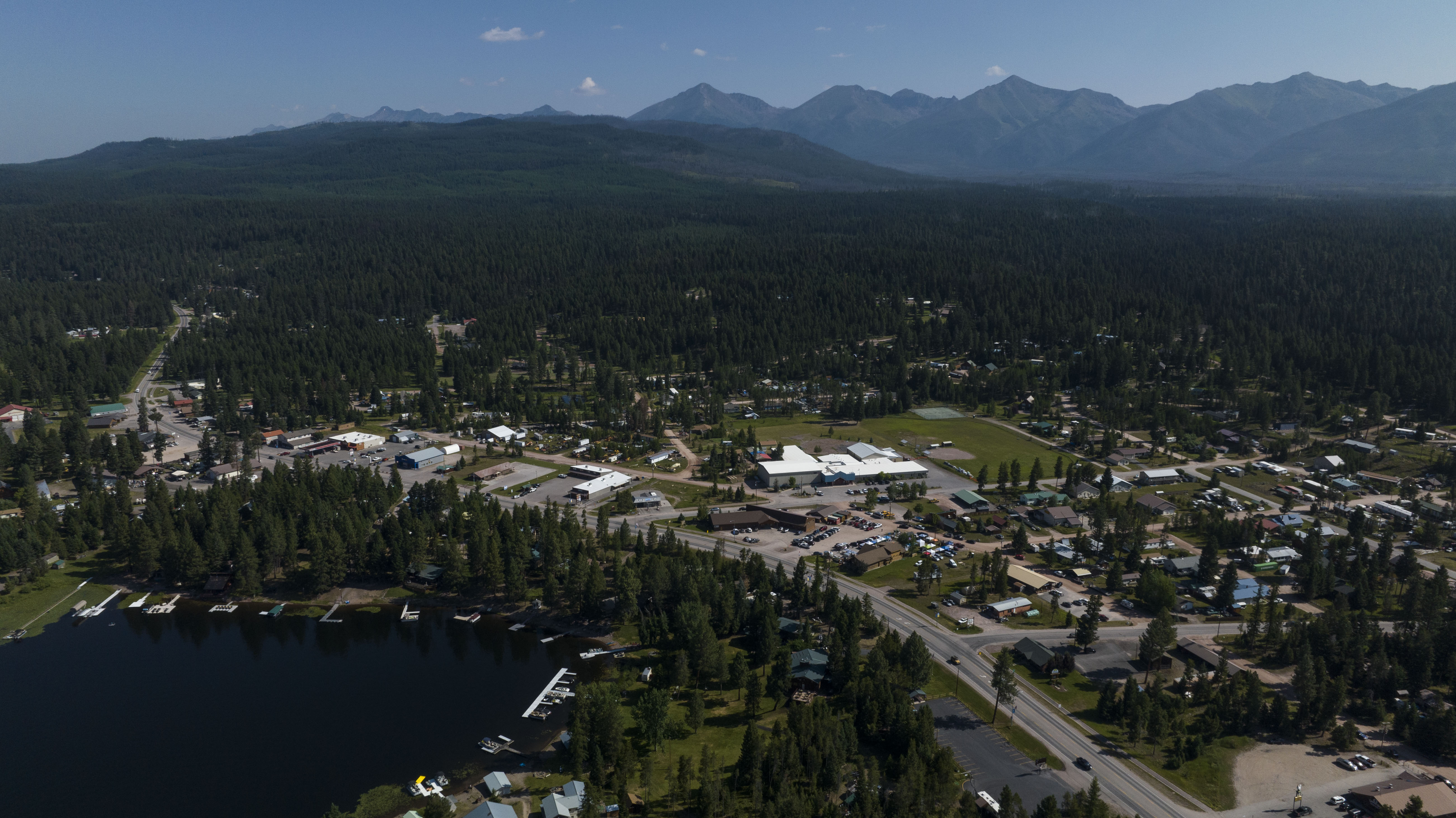Aerial view of downtown Seeley Lake in summer with mountains in the background