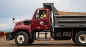 Smiling Public Works staff driving a maintenance truck